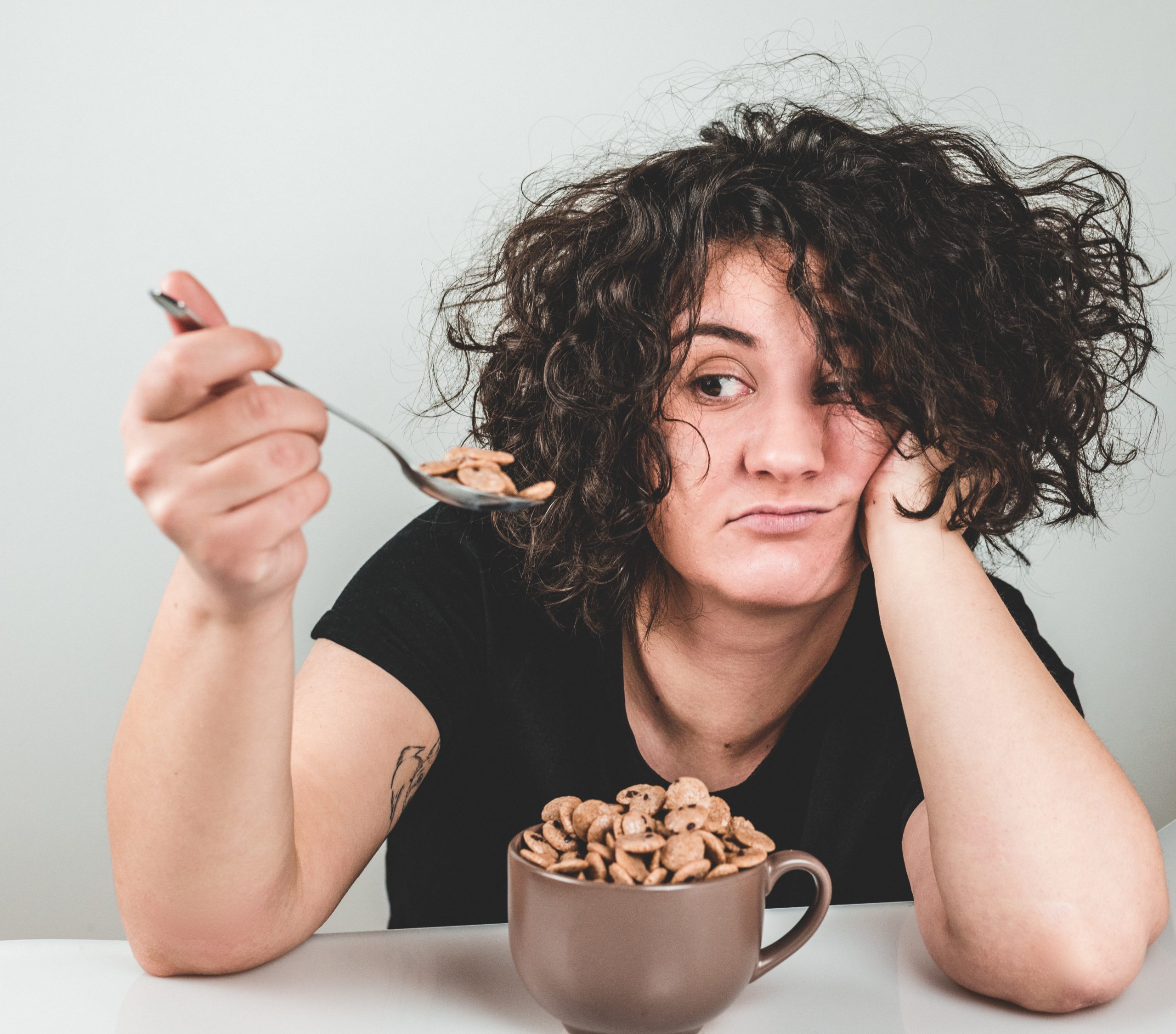 young-woman-has-no-appetite-to-eat-food-sitting-in-front-of-breakfast