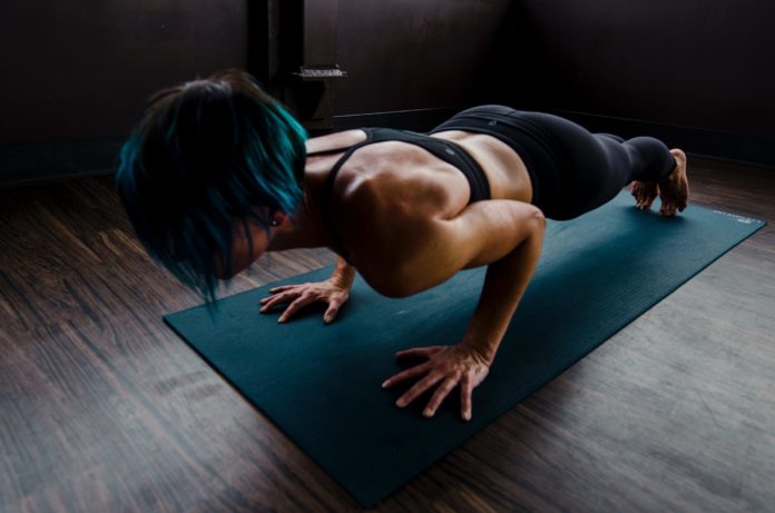Woman doing push ups on a yoga mat