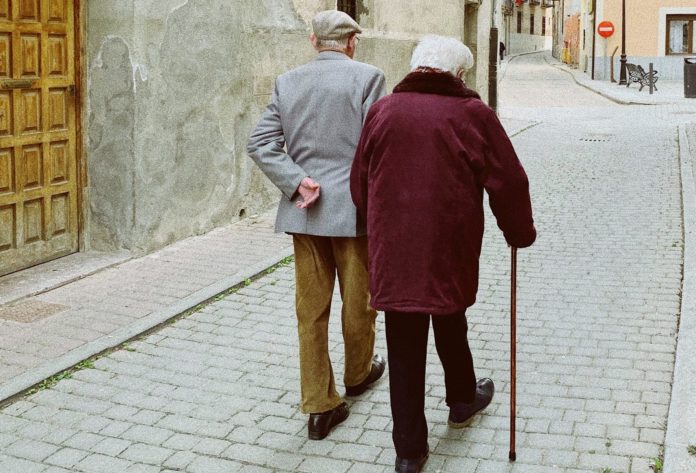 An old couple walking along a path