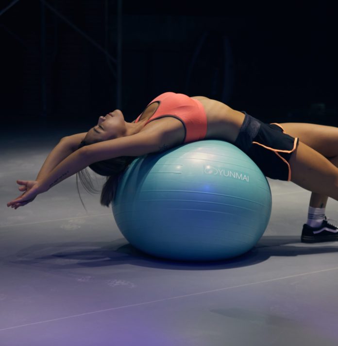 Woman stretching over yoga ball