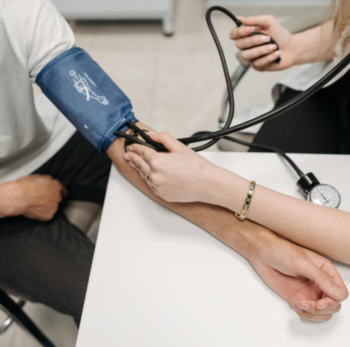 A Healthcare Worker Measuring a Patient's Blood Pressure Using a Sphygmomanometer
